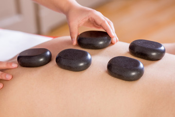 Detail of hands massaging back of a person