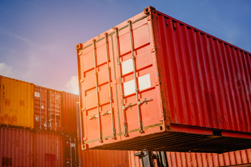 Fototapeta premium Close-up container box Forklift truck handling cargo shipping in logistic shipping yard with cargo container stack in background