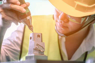 Young engineer is using a CNC machine to check the size, check the size of 3D parts after going...