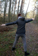 woman does physical exercises in the autumn forest