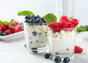 Cottage cheese with cream, raspberry and blueberry garnished with fresh mint.
