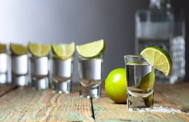 Tequila with  salt and lime on a old wooden background.