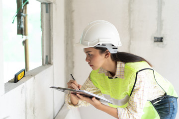 Fototapeta premium Female worker occupation. Woman inspector / architect checking interior material process in house reconstruction project.