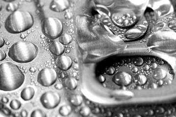 Aluminum can of beverage covered with water drops on background, closeup
