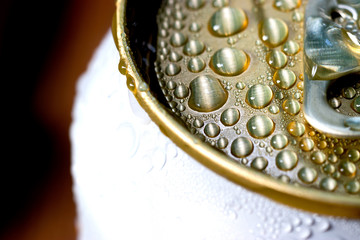 Aluminum can of beverage covered with water drops on background, closeup