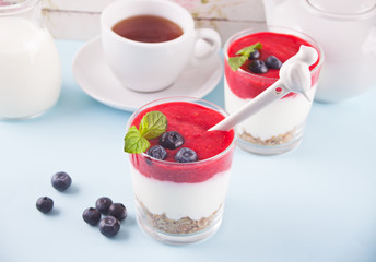 Bowls of breakfast healthy muesli with blueberry, strawberry and yogurt.