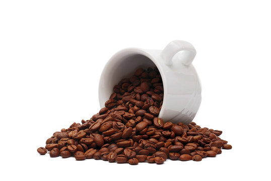 overturned white coffee cup overfilled with roasted coffee beans isolated on white background