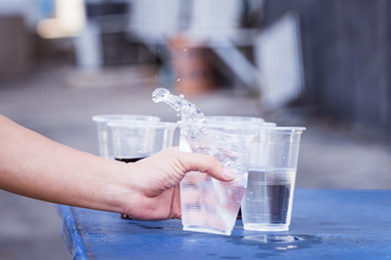 Hand is catching a glass of water.