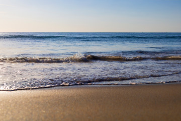 Soft wave from sea come to wet sand beach with blur clear sky background. With copy space for text or design