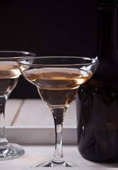 White wine in a glasses, bottle on the white wooden tray. Dinner for two.