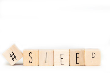 Wooden cubes with a Hashtag and the word Sleep isolated on white background, social media concept...