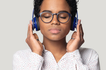 Beautiful african woman wearing headphones listen favourite music studio shot
