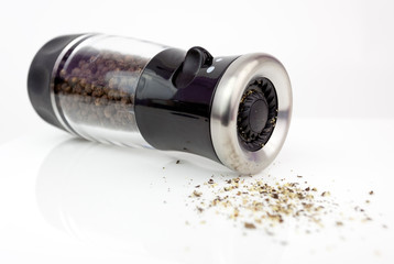 Glass pepper mill isolated on white background.