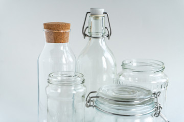 A variety of glass jars and bottles at white backdrop. Zero waste concept.