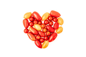 Tomato heart on white background. Different red and yellow fresh, organic tomato in shape of heart. Diet and nutrition concept.