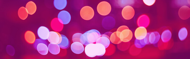 Abstract colorful blurry cinematic background bokeh. Defocused pink, violet, pirple, yellow evening night street romantic lights. Web banner header for website.