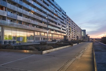 Fototapeta na wymiar Urban street with modern buildings in sunset twilight colors
