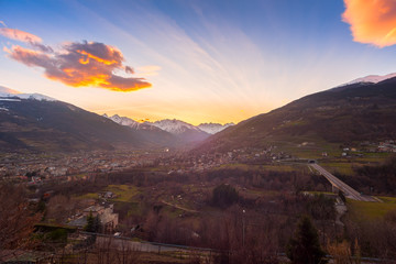 Panorama of Aosta city at sunset, with mountains on background and colorfull sky