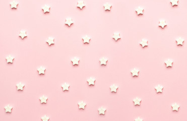 White sweet star lollipops on a pink background macro view