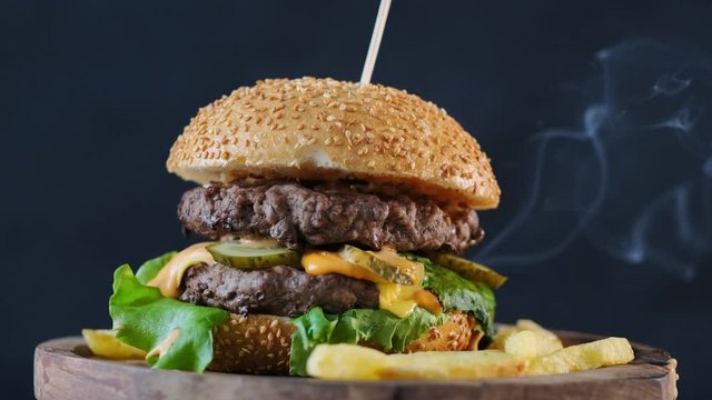 Close up of juicy burger on smoke backrgound