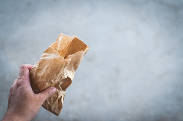 man hand holds used paper bag