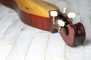Appalachian mountain dulcimer musical instrument on a rustic white wooden background