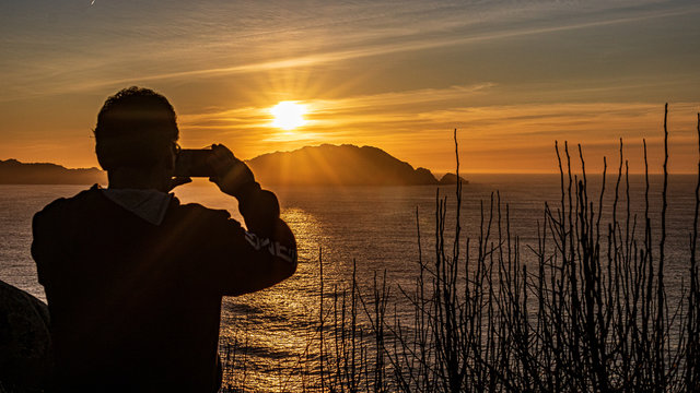 silhouette of a man in the sunset taking photo