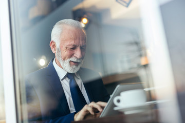 Senior businessman working on a tablet computer