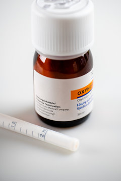 Maienfeld, GR / Switzerland - 4 December 2020. macro shot of liquid oxycodone bottle and oral medication syringe