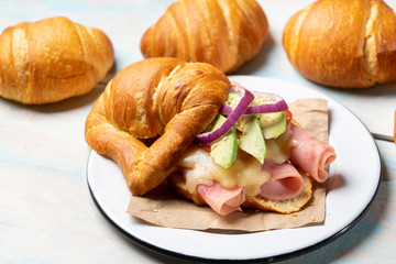 Butter croissant bread with ham and cheese on wooden background