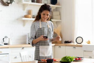 Woman holding smartphone using cooking apps websites search recipes