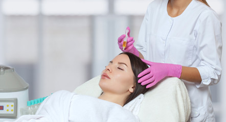Cosmetologist does prp therapy against hair loss of a beautiful woman in a beauty salon. Treatment...