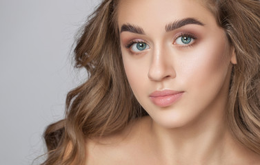 Portrait of a beautiful woman with long eyelashes, beautiful fresh nude make-up, thick eyebrows and...