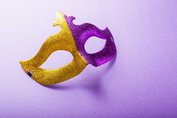 A festive, colorful group of mardi gras or carnivale mask on a purple background. Venetian masks.