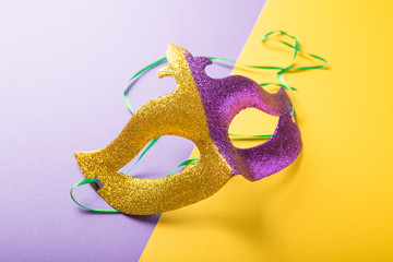 A festive, colorful group of mardi gras or carnivale mask on a yellow purple background. Venetian masks.