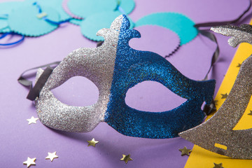 A festive, colorful group of mardi gras or carnivale mask on a yellow purple background. Venetian masks.