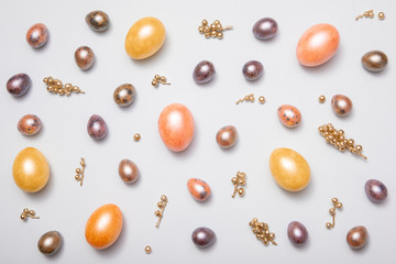 Layout of Easter eggs painted in pastel colors on a white background, top-down view