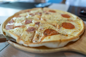Delicious Peperone Pizza in wooden plate for lunch