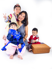 Fototapeta premium Asian little boy and girl wearing a Korean Traditional Hanbok dress in Rattan bag on white background