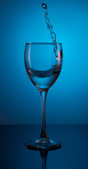 splash of water in a glass on a beautiful gradient blue background