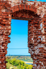 View through window hole of ruined red brick building