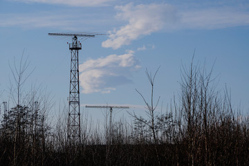 antenna at the airport, radar system near the airport, against a blue clear sky with a small cloud....