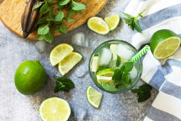 Summer cold drink and cocktail. Fresh Mojito cocktail with lime, ice and mint in a glass on a gray...