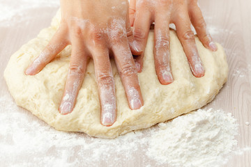 Dough for festive baking in the skillful hands of the hostess close-up, Russia