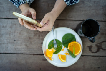 Girl using mobile phone while enjoy drinking coffee.
