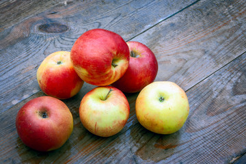 Ripe red apples on a wooden table background. Ripe red apples on table close up.