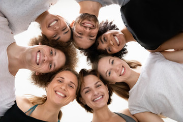 Low angle smiling diverse people standing in circle, celebrating success