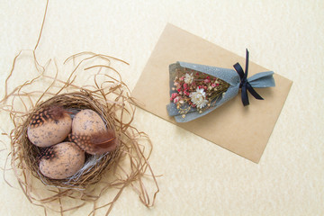 Easter composition religious concept. Golden eggs in a nest with partridge feathers. An envelope...
