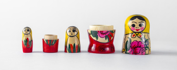 Three wooden nesting dolls demonstrate the continuity of generations on a light isolated background.