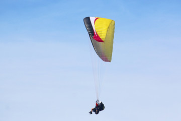 Tandem Paraglider flying wing in a blue sky	
